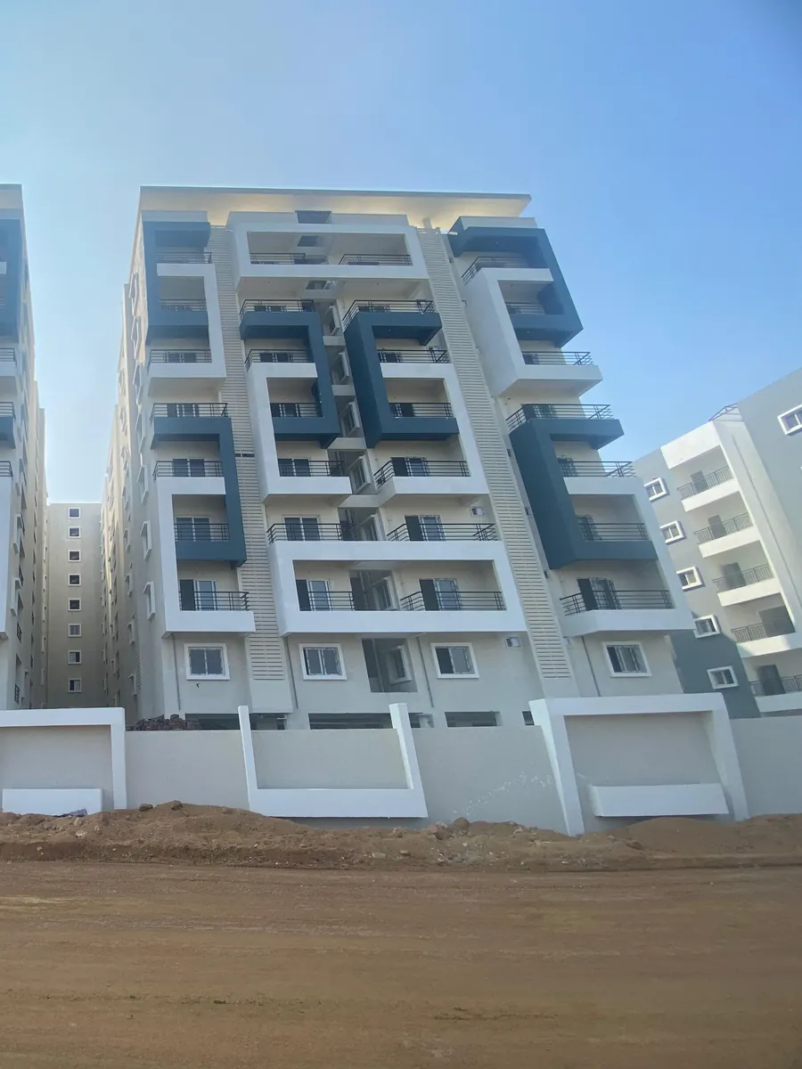 An apartment tower with balconies and slate-grey frames seen from the road at HPR Lakefront